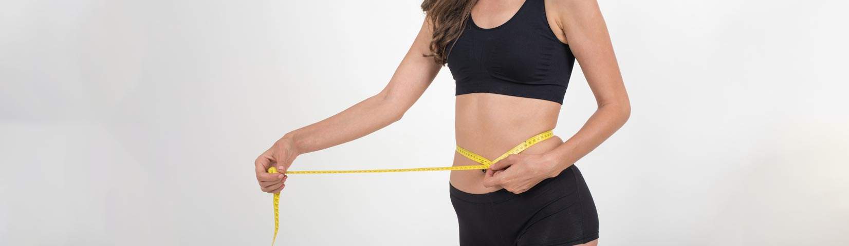 portrait beautiful young woman measuring her figure size with tape measure